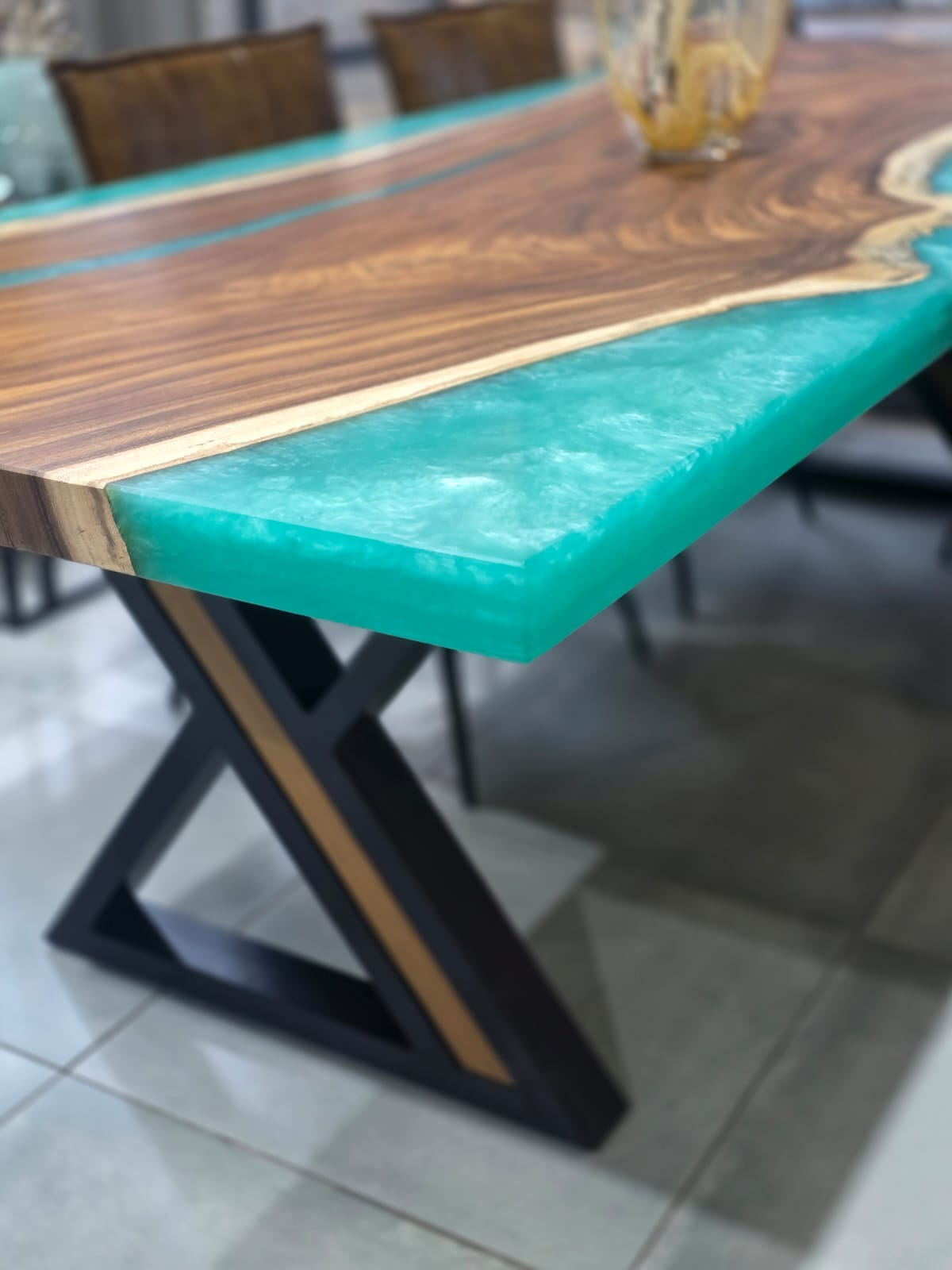 Jade resin river through a walnut live-edge top on a cross-brace base